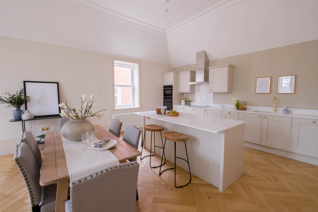 A wide-angle photograph showing a well-lit kitchen and dining area inside of a Gloucestershire based residential property.